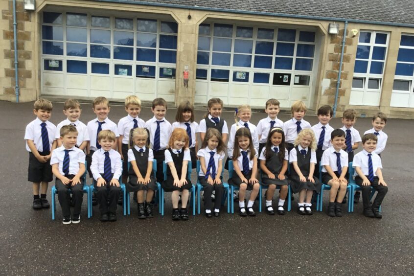 Bishopmill Primary School's class P1G in two rows in front of the school