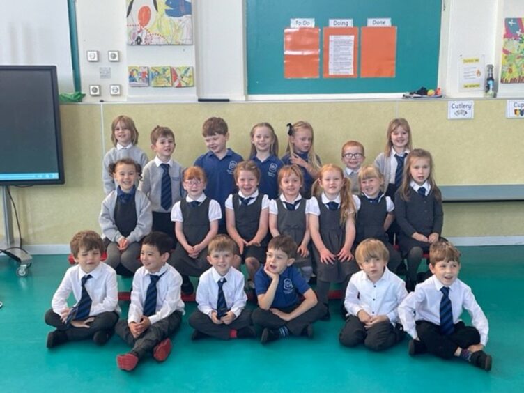 Class P1KF at Bishopmill Primary School in three row in their classroom