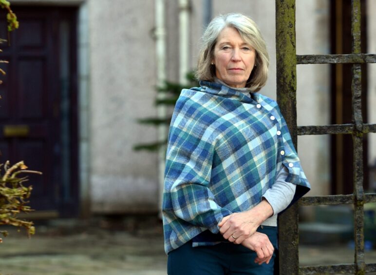 Professor Claire Wallace in a blue tartan pashmina looking at the camera. 