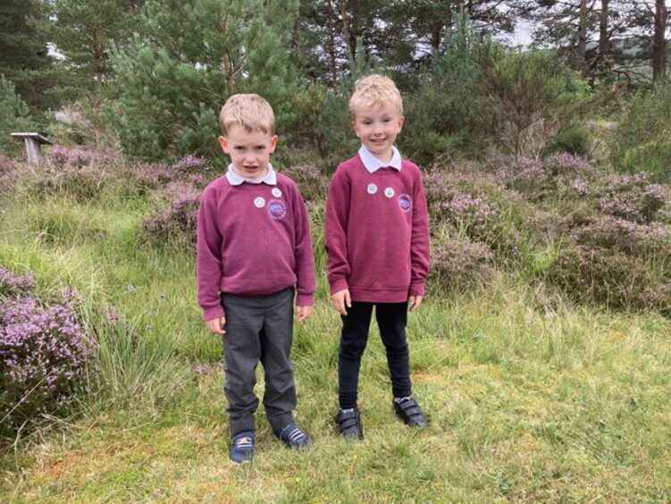Two Cannich Bridge Primary pupils standing outside on the grass