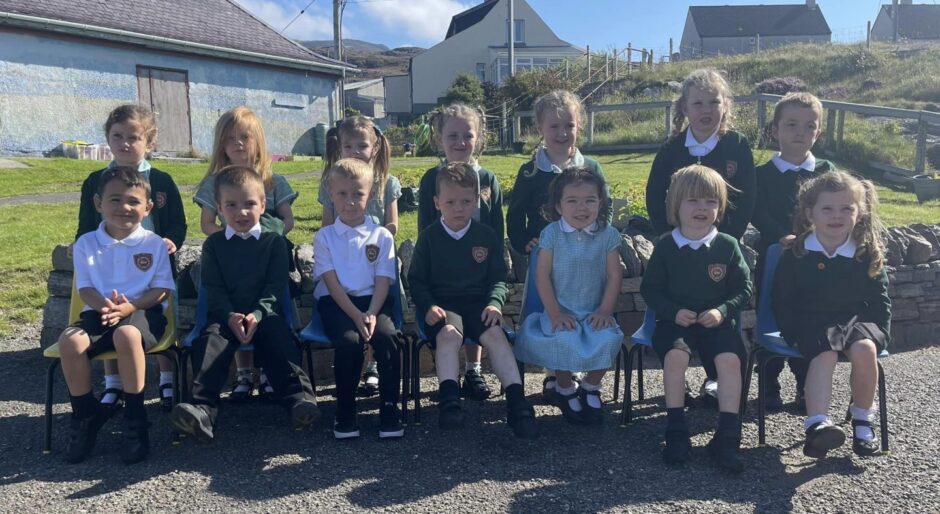 Castlebay Primary School pupils in two rows outside the school