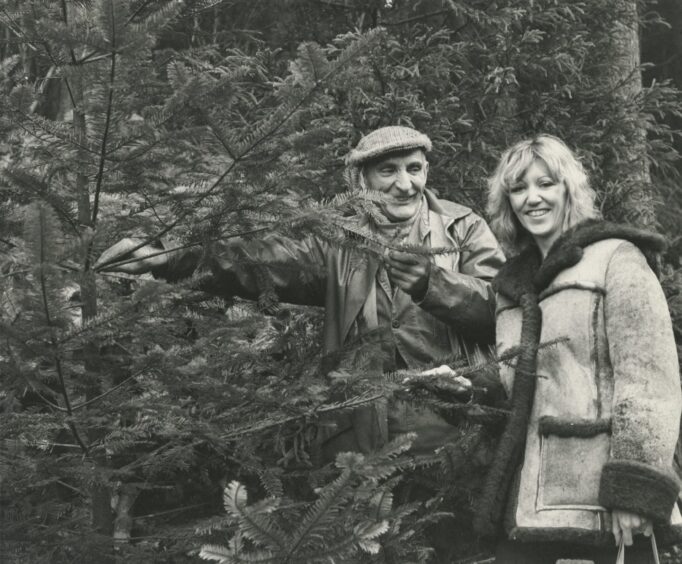 A man and woman standing in the trees