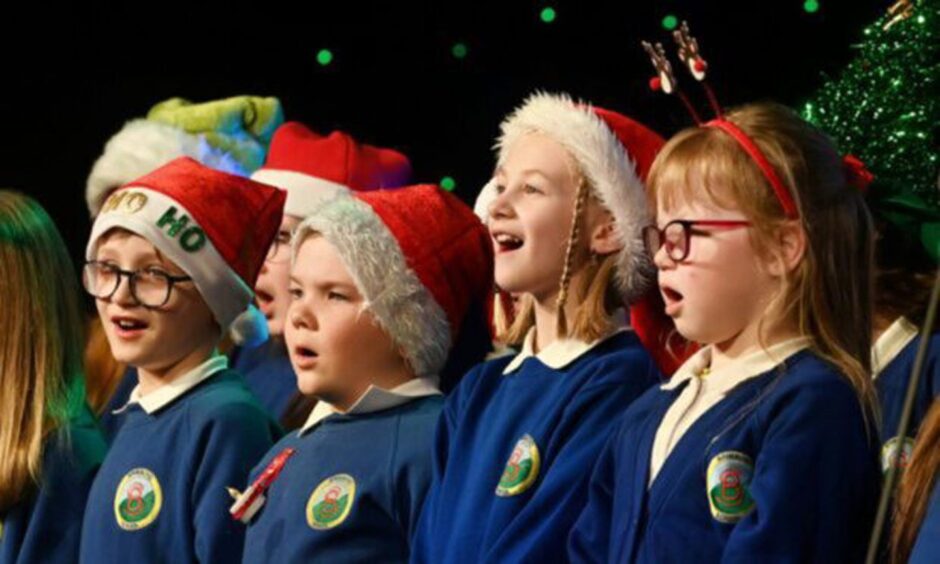 Children singing in santa hats at the Press & Journal Evening Express Christmas Concert