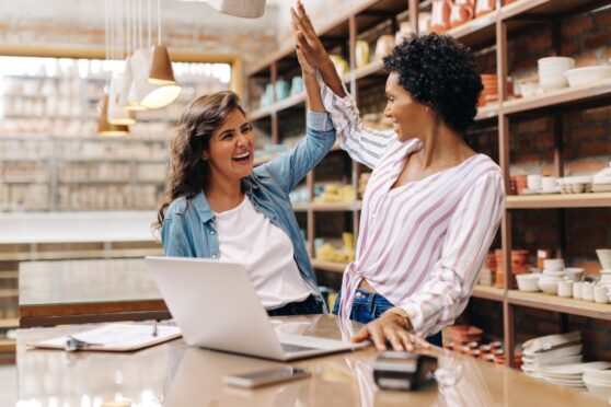 Ceramic shop owners high fiving each other after deciding to sell a business in the UK