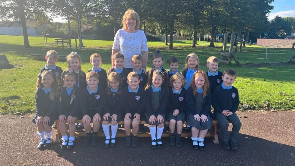 Crombie School P1 students with Mrs Smith behind them outside in the playground