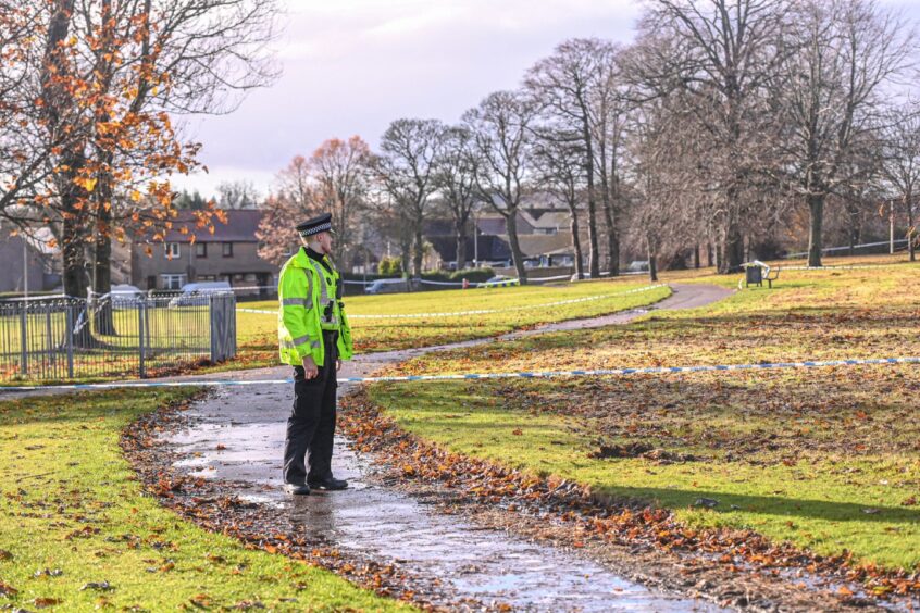 An officer standing guard at the scene in Eric Hendrie Park on Saturday