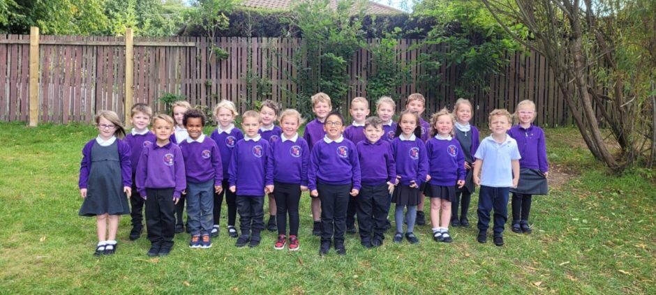 Duncan Forbes Primary pupils lined up in rows on the grass outside