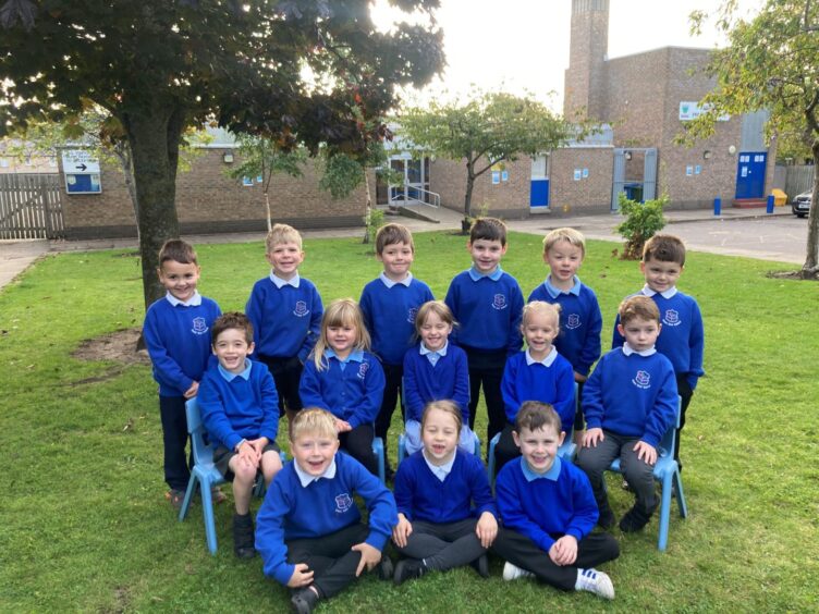 First class of 2023 at East End Primary School in Moray. The children are in three rows on the grass outside the school