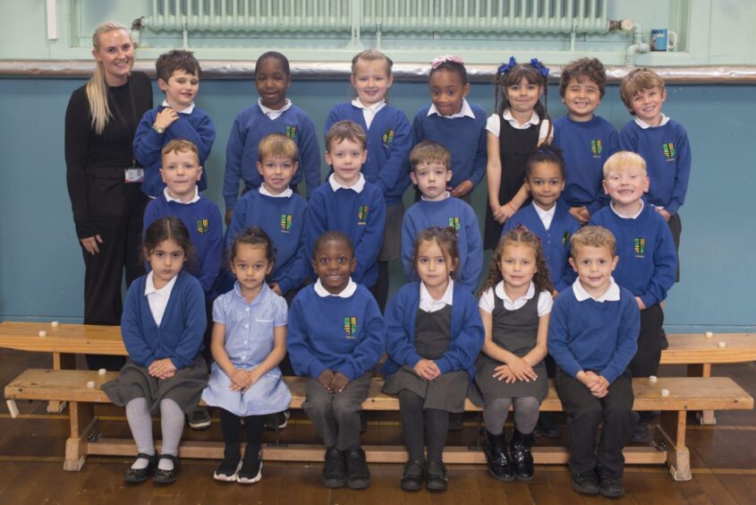 Ferryhill Primary School's class P1C in three rows with Miss Cruden standing next to them
