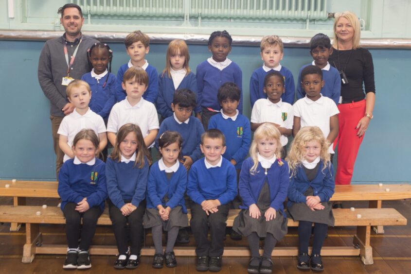 Class P1G in three rows of six with Mr Gordon and Ms Sangster on either the side of the back row