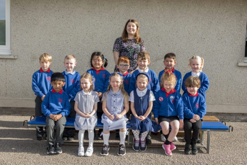Class P1.2 outside Forehill Primary School in Aberdeen, getting their First Class 2023 photo taken with their teacher