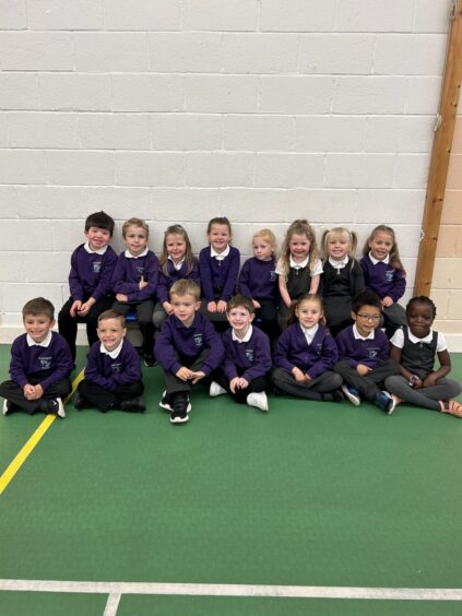 Class P1CW at Glashieburn Primary School in two rows in the gym hall