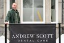Dentist Dr Gregor McPherson stood next to the sign outside Andrew Scott Dental Care private dentist clinic in Aberdeen.