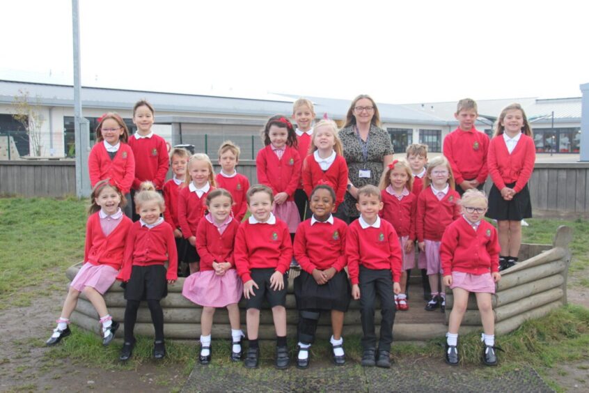 Class P1MW at hillside School with their teacher outside in the playground