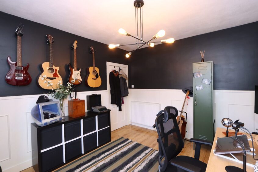 Another view of the office, showing four guitars hanging on the wall
