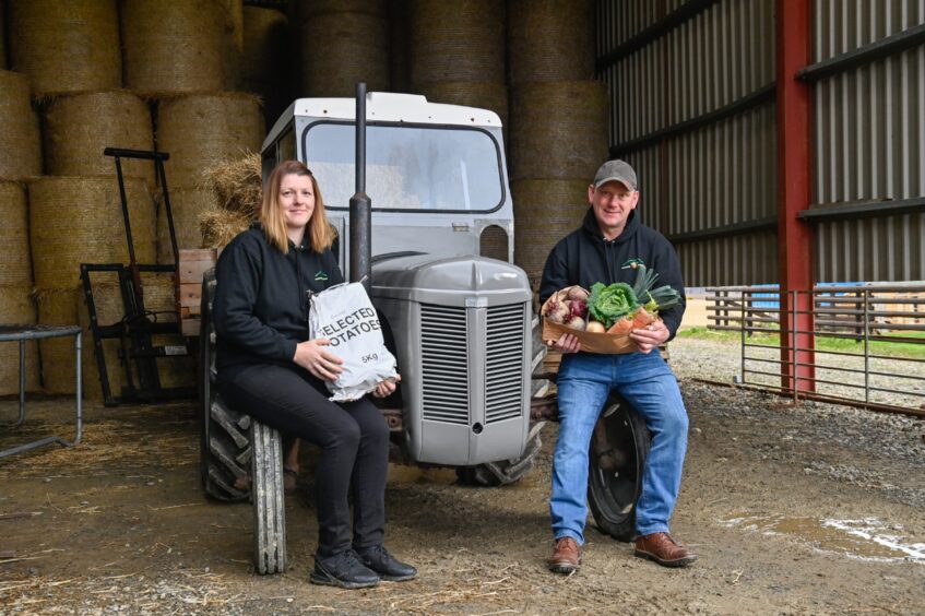 The couple holding fresh produce at their farm near Portsoy.