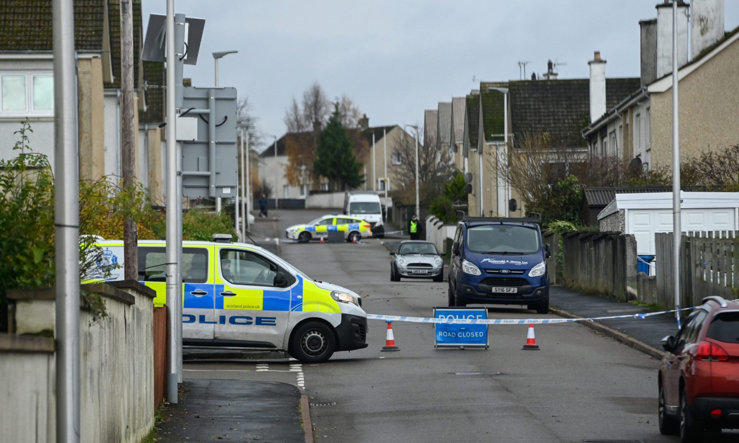 Police cars blocking entrance to a cordon in New Elgin. 