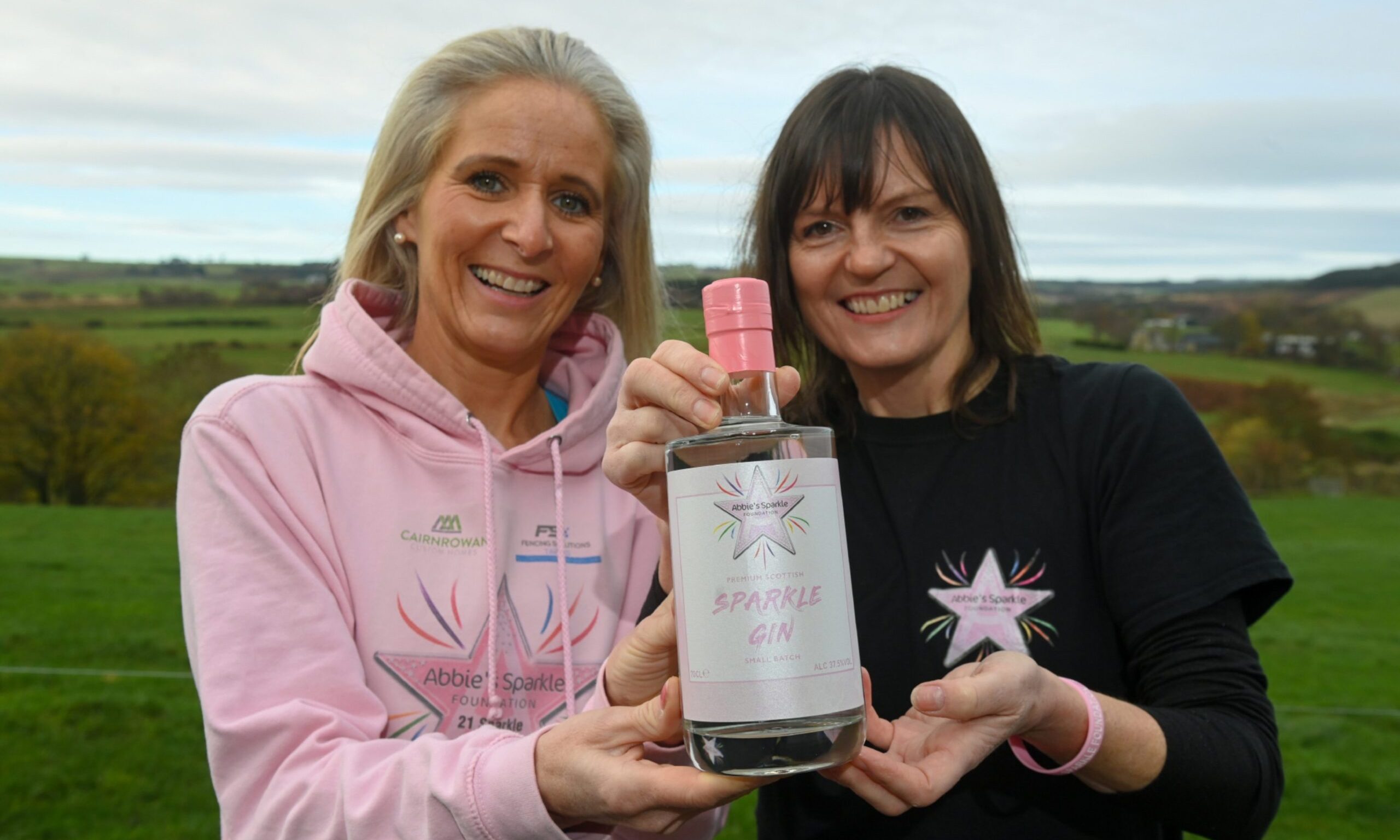 Lauren Donald and Tammy Main holding bottle of gin. 