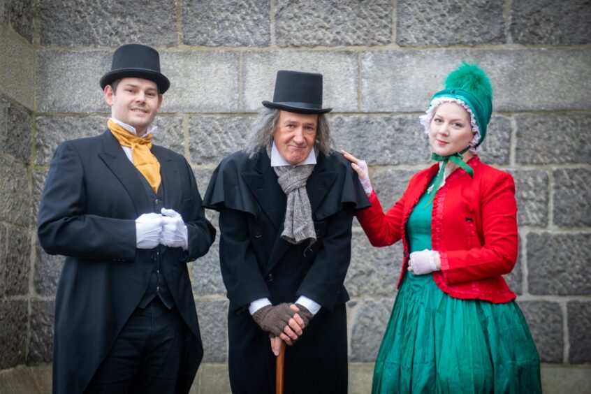 Right to left, are Ian Baxter as Harry, Colin Campbell as Scrooge and Katie Baxter as Helen dressed in costume standing outside Ferryhill parish Church in Aberdeen/ 