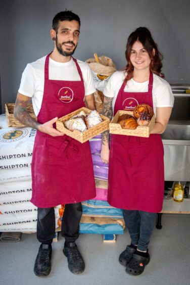 Claudio and his wife Alex holding baked goods