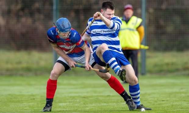 Robert Mabon (Kingussie) battles for the ball with Steven Macdonald (Newtonmore). Image: Neil Paterson.