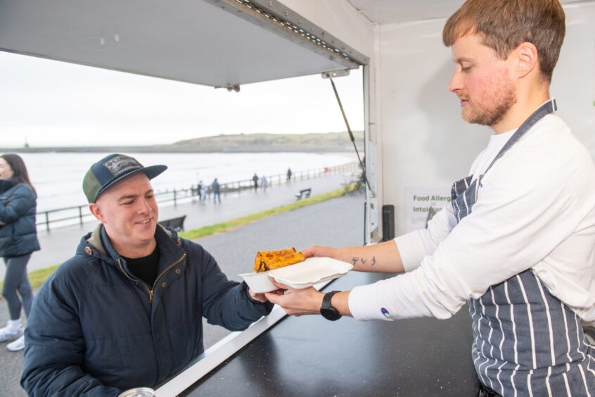 Derek serving a customer at his new food truck.