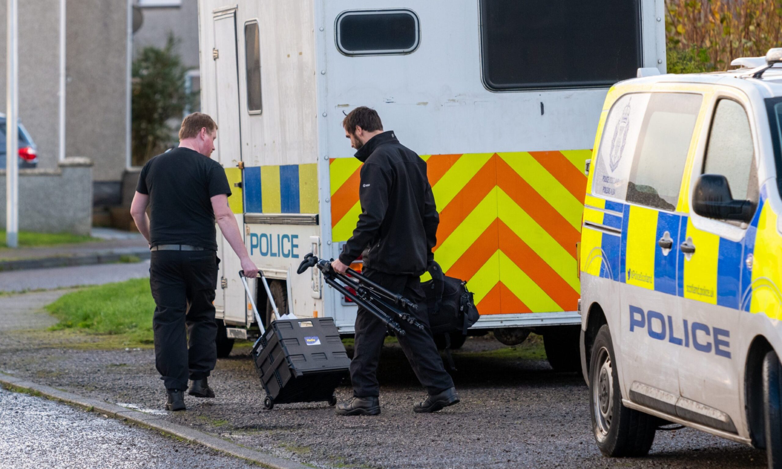 Police officers with a box and tripod on Anderson Drive. 