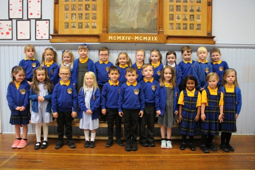 First class of 2023 at Kemnay Primary School in Aberdeenshire standing in two rows against a wall in the school