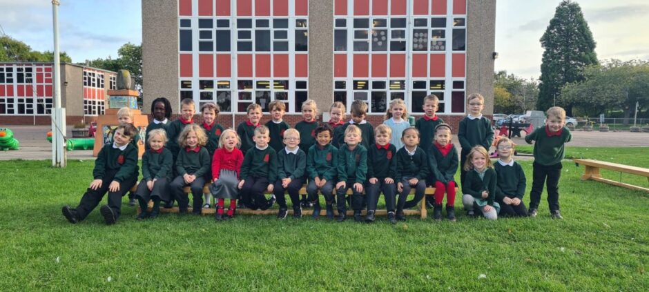 First class of 2023 at Kinloss Primary School in Moray in two rows outside the school