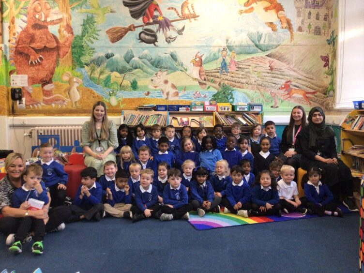 First class of 2023 at Kittybrewster School in the school library. The Aberdeen pupils are sitting in three rows, with teachers and staff members sitting beside them