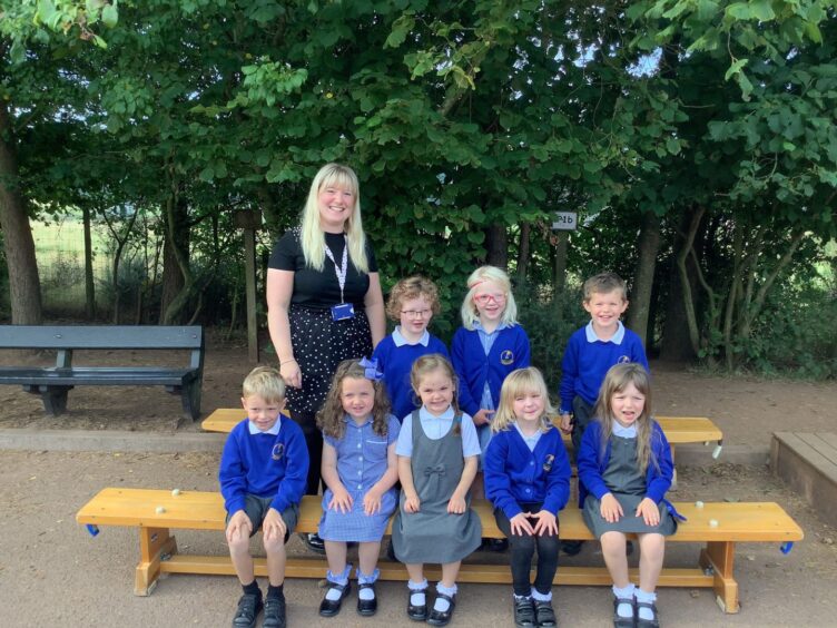 P1-2 at Laurencekirk Primary School with Miss MacBean standing next to them outside