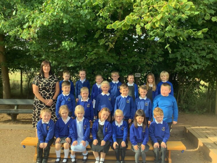 Class P1A at Laurencekirk Primary School with Ms Easton standing with them outside the school