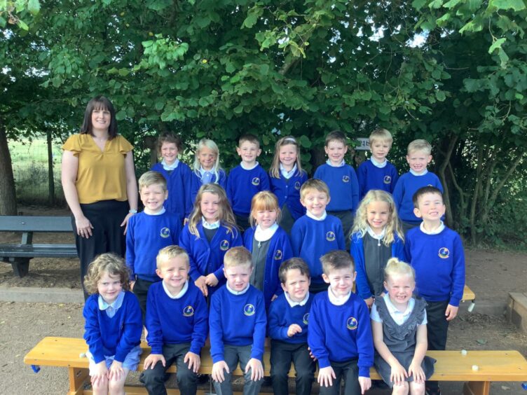 Class P1B at Laurencekirk Primary School, with their teacher Mrs Crowther standing beside them outside the school