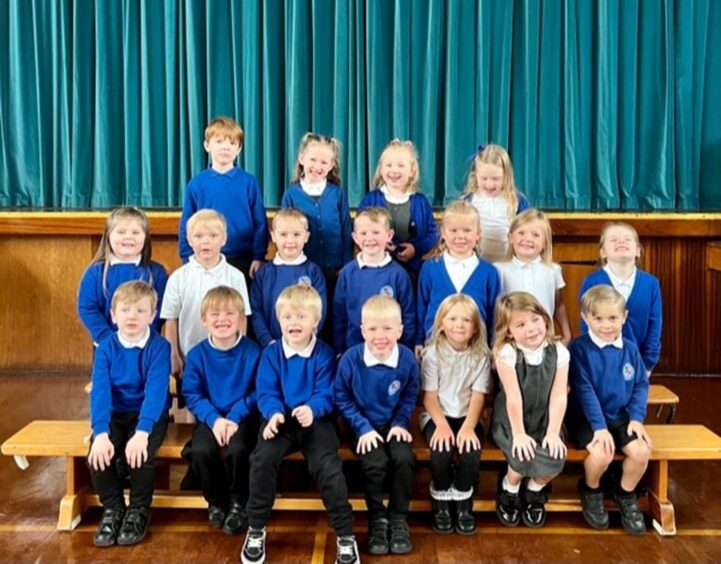 Macduff Primary's first class of 2023 in three rows inside the Aberdeenshire school's assembly hall