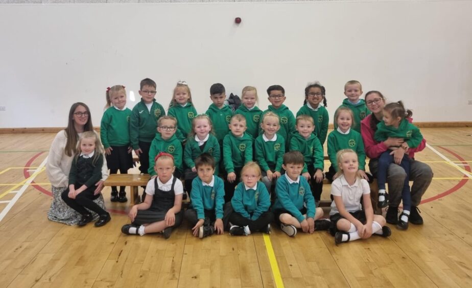 Manorpark Primary School pupils in three rows in the PE hall with a teacher on either side