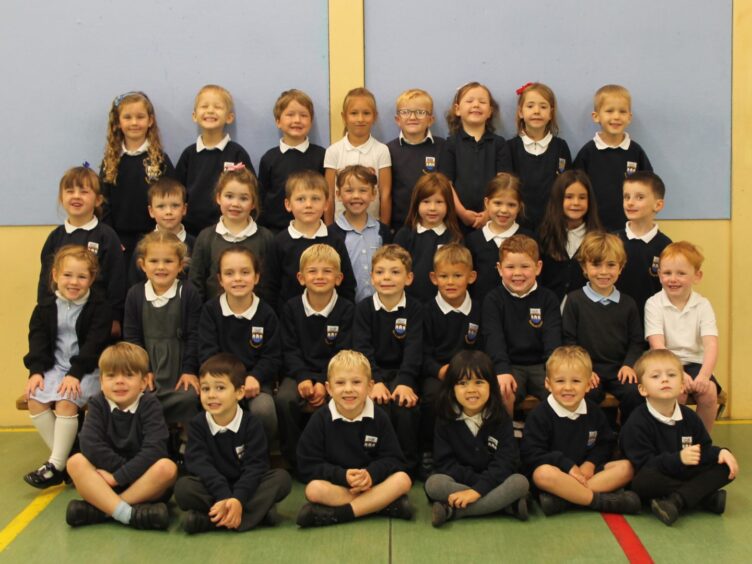 Four rows of pupils at Meiklemill Primary School in the gym hall.