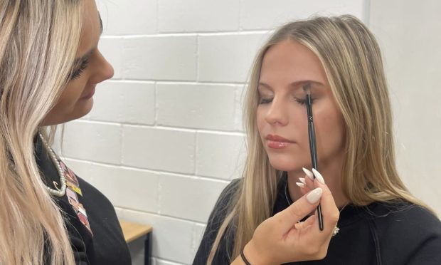 Meldrum Academy's Charlotte Kettle applies make-up to fellow pupil Ava Baxter. Image: Jamie Beatson