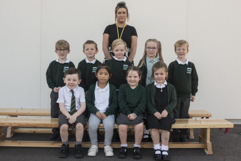 Class P1-2 at Milltimber Primary School with their teacher standing behind them