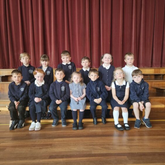 First class of 2023 at Monquhitter School in Aberdeenshire in two rows in the assembly hall