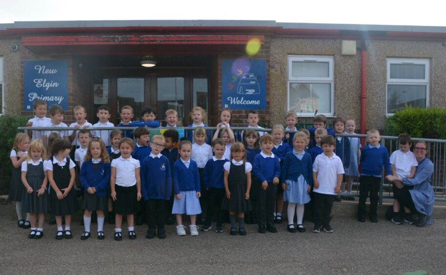First class of 2023 at Moray school New Elgin Primary School outside the school entrance with a member of staff