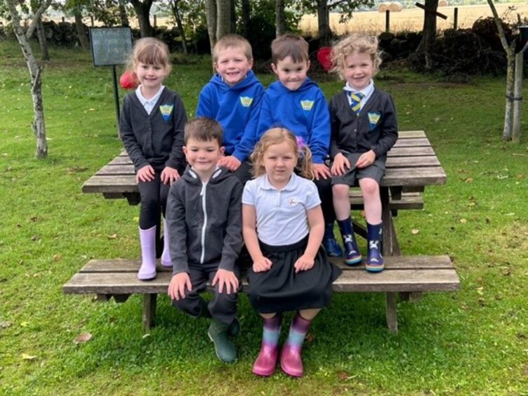 Ordiquhill Primary pupils sitting on a picnic bench in the playground