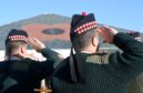 Soldiers from 3SCOTS salute a giant poppy on the roof of The Hub in Inverness