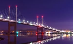 Lights from the Kessock Bridge reflect in the firth below.