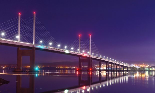 Lights from the Kessock Bridge reflect in the firth below.