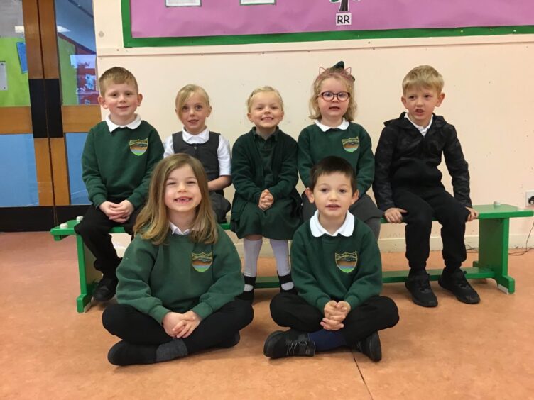 First class of 2023 at Rhynie Primary School in Aberdeenshire. Five pupils are sitting on a bench and two are sitting on the floor at the front