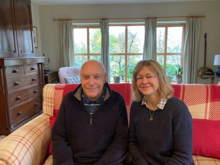 Roger and Katherine Williams sitting on a sofa in their inverurie home after the renovation