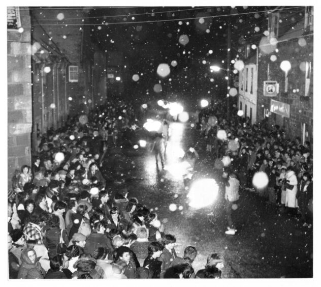 Crowds gather on the high street to watch the fiery spectacle. Supplied by DCT Archives.