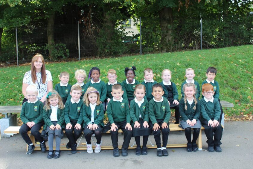 Class P1W outside Stoneywood School. The children are in two rows with their teacher at the far left of the back row.