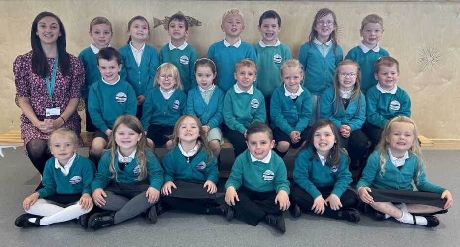 Class P1C from Uryside School arranged in three rows with their teacher sitting next to them