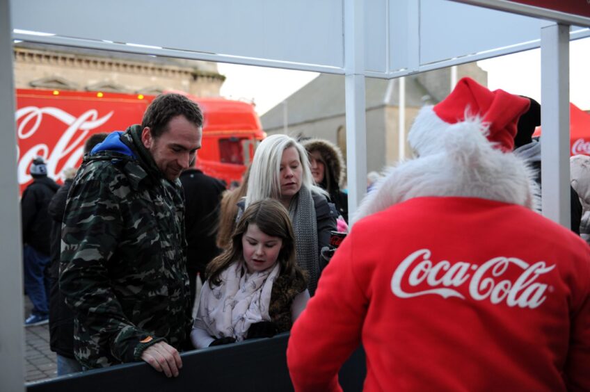 Families enjoying the visit of Santa during the Coca Cola truck tour.